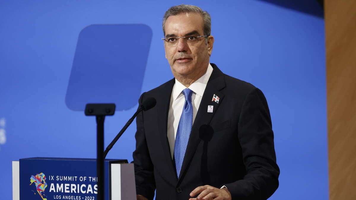 Dominican President Luis Abinader speaking at a podium at the Summit of the Americas
