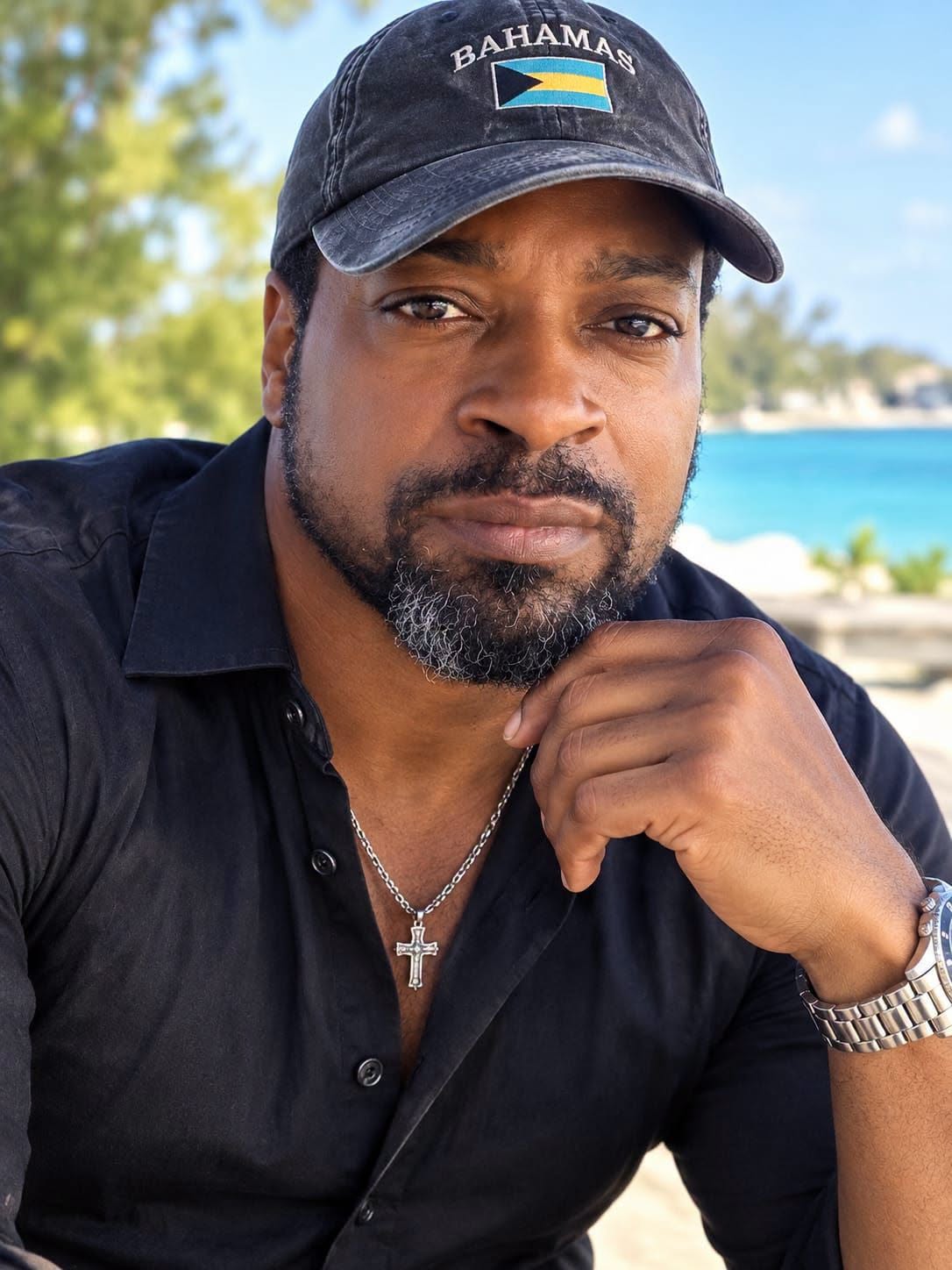 Man in a Bahamas cap by the sea