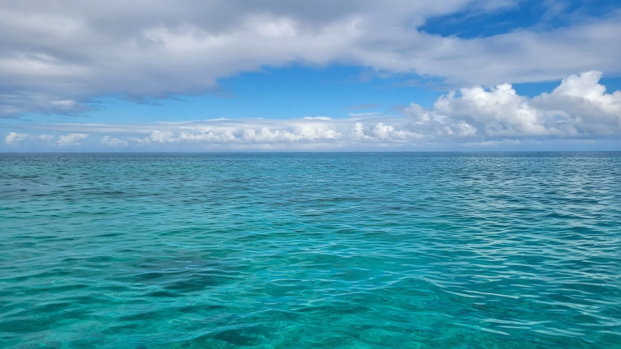 AI-generated illustration of a calm turquoise Caribbean sea under partly cloudy skies