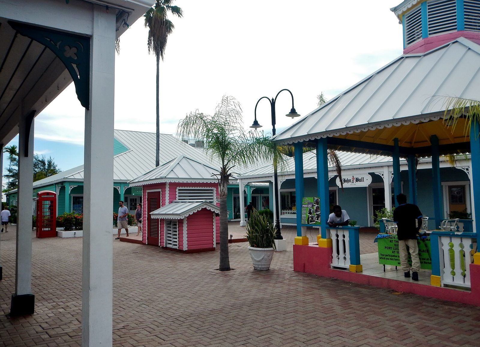 Brick walkway lined with brightly painted shops, gazebos and palm trees at Port Lucaya Marketplace in Freeport