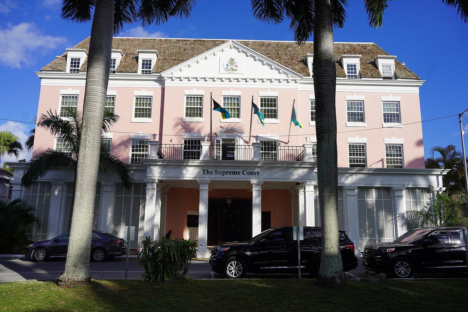 Pink Supreme Court of The Bahamas building behind palm trees in downtown Nassau